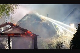 Woning met rieten kap beschadigd na brand in schuur